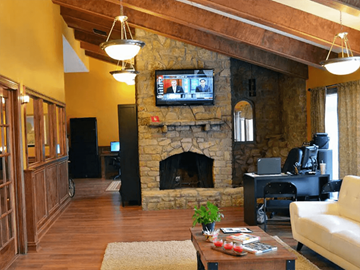 Beavercreek apartment for rent - a living room with a stone fireplace and a tv above it