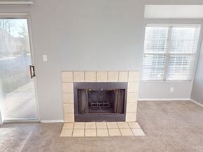 Florissant apartment for rent - A living room with a fireplace and a sliding glass door.