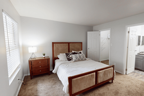 Florissant apartment for rent - A bedroom with a bed, nightstand, and window.