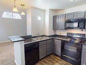 Florissant apartment for rent - A kitchen with a black stove top oven and microwave.