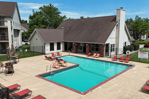 Florissant apartment for rent - A pool with red chairs and a white house in the background.