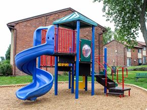 Charlack townhouse for rent - a playground with a blue slide in front of a brick building