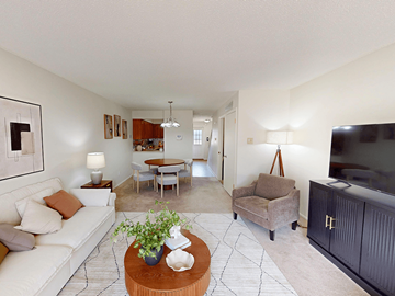 Ballwin townhouse for rent - A living room with a white couch and a coffee table with a plant on it.