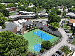 Ballwin townhouse for rent - A tennis court is surrounded by a parking lot and buildings.