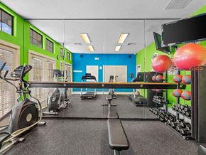 Topeka apartment for rent - a gym with weights and cardio equipment in a room with green and blue walls