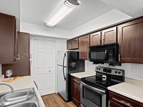 Topeka apartment for rent - a kitchen with black appliances and wooden cabinets
