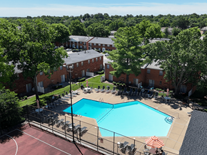 Sappington townhouse for rent - A pool surrounded by chairs and trees in a residential area.