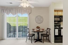 St. Louis apartment for rent - A dining room with a table set for two and a view of a green lawn outside.