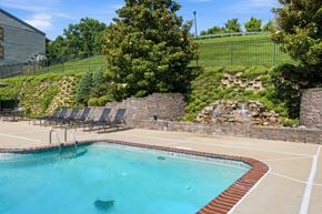 St. Louis apartment for rent - A pool with a waterfall and a stone wall.
