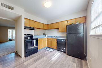 St. Louis townhouse for rent - A kitchen with wooden cabinets and black appliances.