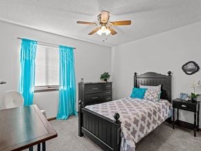 Topeka townhouse for rent - a bedroom with a bed and a ceiling fan