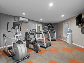 Topeka townhouse for rent - a gym with several exercise bikes and a tv