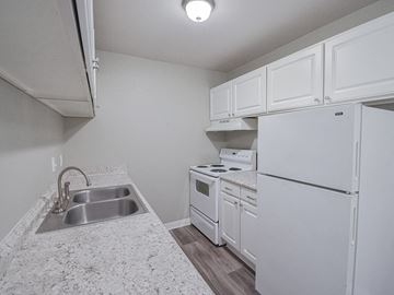 Wichita townhouse for rent - A small kitchen with white appliances and cabinets.
