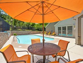 Kansas City apartment for rent - a patio with a pool and a table with an umbrella