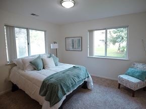 Spring Lake apartment for rent - a bedroom with a bed and a chair and two windows