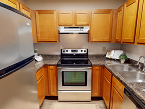 Ofallon townhouse for rent - A kitchen with wooden cabinets and a stainless steel refrigerator.