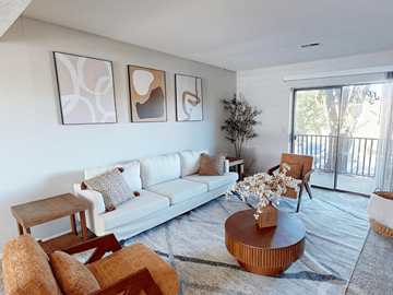 Ofallon townhouse for rent - A living room with a white couch, a coffee table, and three abstract paintings on the wall.
