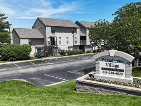 Ofallon townhouse for rent - A sign for Westchester Village Apartments is in front of a building.