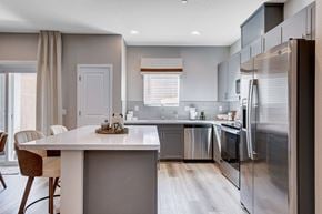 Las Vegas townhouse for rent - A modern kitchen with a dining table and chairs.at Copper Creek Apartments, Las Vegas, NV