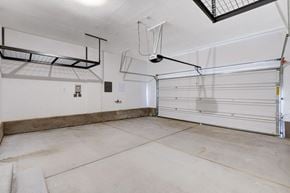 Las Vegas townhouse for rent - A spacious garage with a white floor and a ceiling fan.at Copper Creek Apartments, Las Vegas, NV 89123