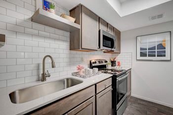 A kitchen with a white sink and black oven.