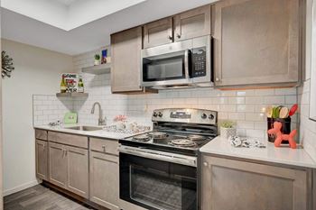 A modern kitchen with a stove, oven, and microwave.