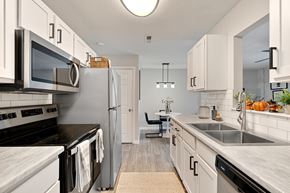 Greenville apartment for rent - A kitchen with white cabinets and a black stove top.