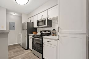 Greensboro apartment for rent - a renovated kitchen with white cabinets and stainless steel appliances