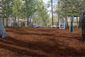Durham apartment for rent - a fenced in play area with trees and a bench