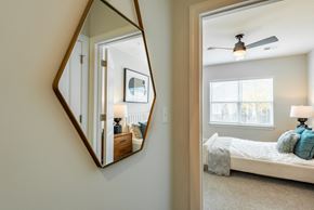 Greensboro apartment for rent - a mirror hanging on a wall next to a bedroom with a bed