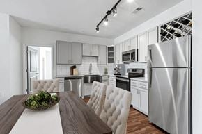 Spartanburg apartment for rent - A modern kitchen with a wooden table and white chairs.