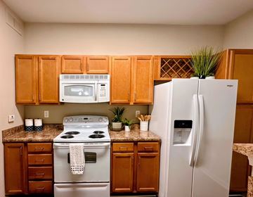 Asheville apartment for rent - A kitchen with a white refrigerator and a white stove top oven.