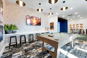 Fruitland Park apartment for rent - A pool table is in the middle of a room with a bar area.