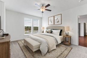 Spartanburg apartment for rent - A bedroom with a large bed, a ceiling fan, and a rug on the floor.