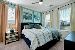 Fruitland Park apartment for rent - A bedroom with a bed, a ceiling fan, and a window with curtains.