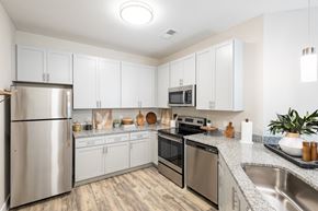 Raeford apartment for rent - a modern kitchen with white cabinets and stainless steel appliances