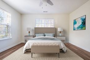 Raleigh apartment for rent - A bedroom with a large bed, a ceiling fan, and a painting on the wall.