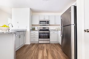 Clayton apartment for rent - A renovated kitchen with stainless steel appliances and white cabinets at Amelia Village apartments in Clayton, NC.