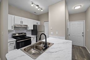 Greensboro apartment for rent - a kitchen with white cabinets and black appliances and a sink