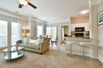 Greenville apartment for rent - A living room with a couch, a bar, and a ceiling fan.
