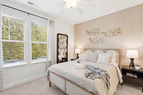 Shallotte apartment for rent - A bedroom with a large bed and a ceiling fan.