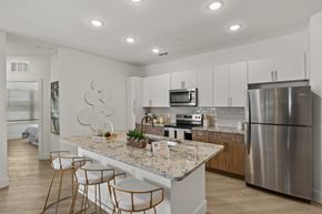 Fort Myers apartment for rent - a kitchen with a marble counter top and a stainless steel refrigerator