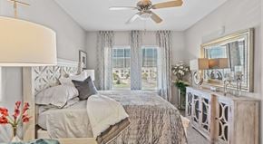 Myrtle Beach apartment for rent - A bedroom with a large bed and a ceiling fan.