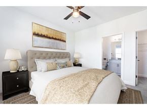 Kernersville apartment for rent - A bedroom with a large bed and a painting on the wall.