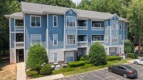 Greensboro apartment for rent - a blue apartment building with cars parked in front of it