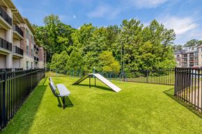 Chapel Hill apartment for rent - A park with a slide and bench in the foreground and apartment buildings in the background.