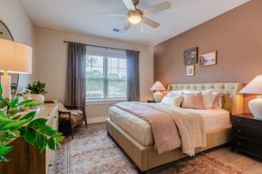 High Point apartment for rent - Bedroom with a Large Bed, Two Nightstands, Dresser and a Ceiling Fan.