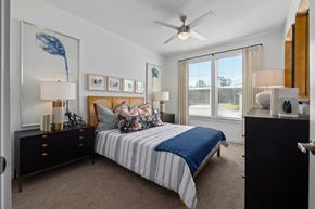 Opelika apartment for rent - A bedroom with a bed, nightstands, and a ceiling fan.