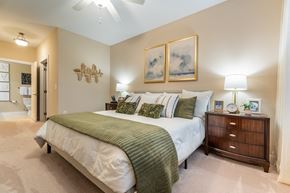 Cary apartment for rent - A bedroom with a large bed and a ceiling fan.