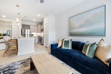 Raleigh apartment for rent - A modern living room with a blue couch and a painting on the wall.